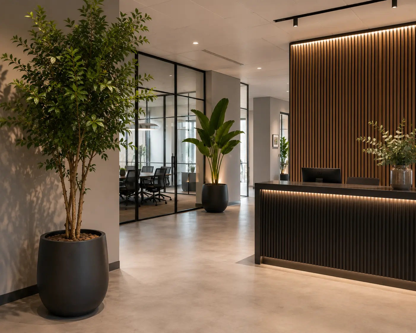 hoogwaardige kunstplanten in zwarte bloempotten bij de receptie van een modern kantoor