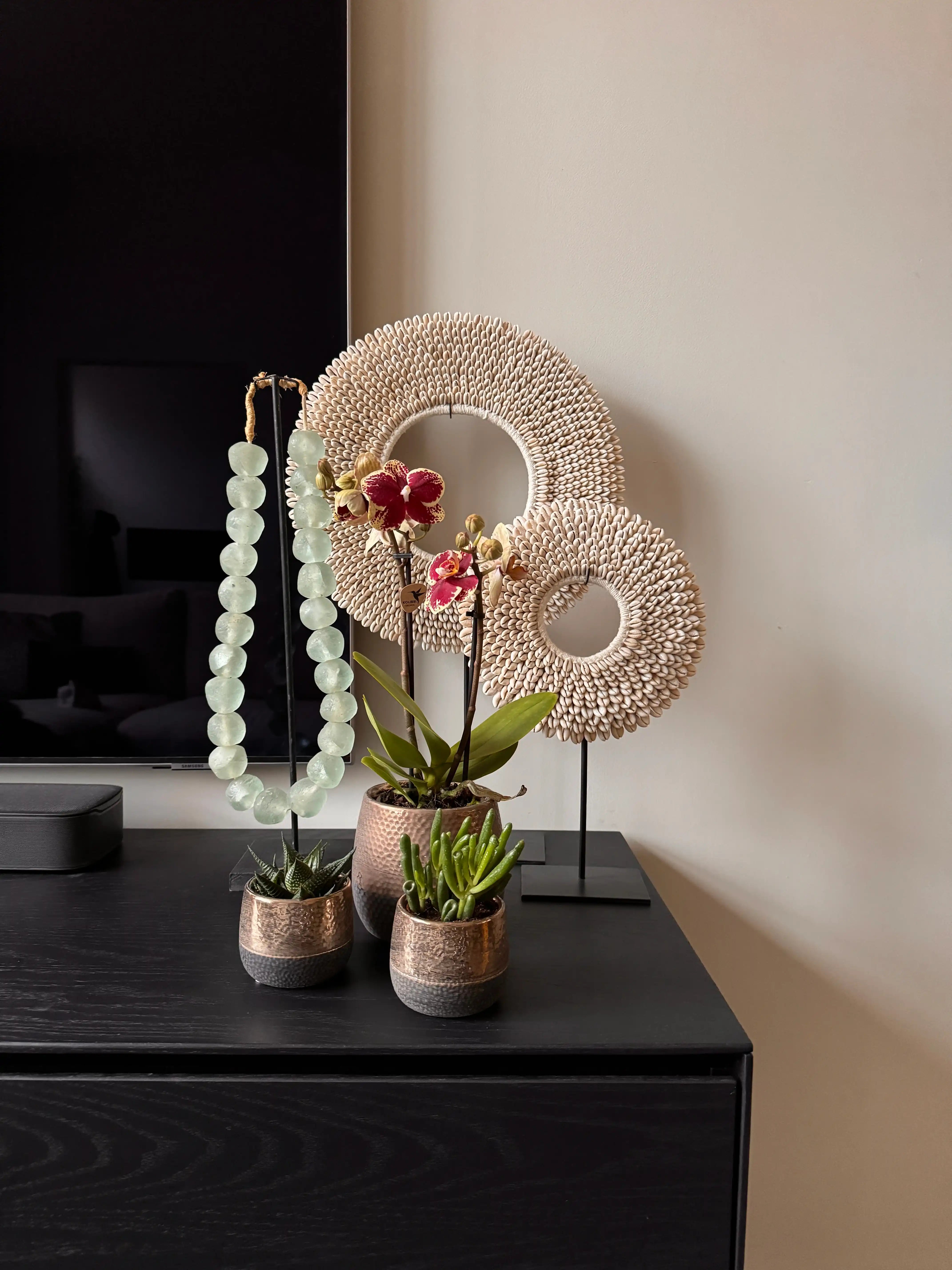 Elite kleine bloempotten in de kleuren zwart en koper op modern tv dressoir
