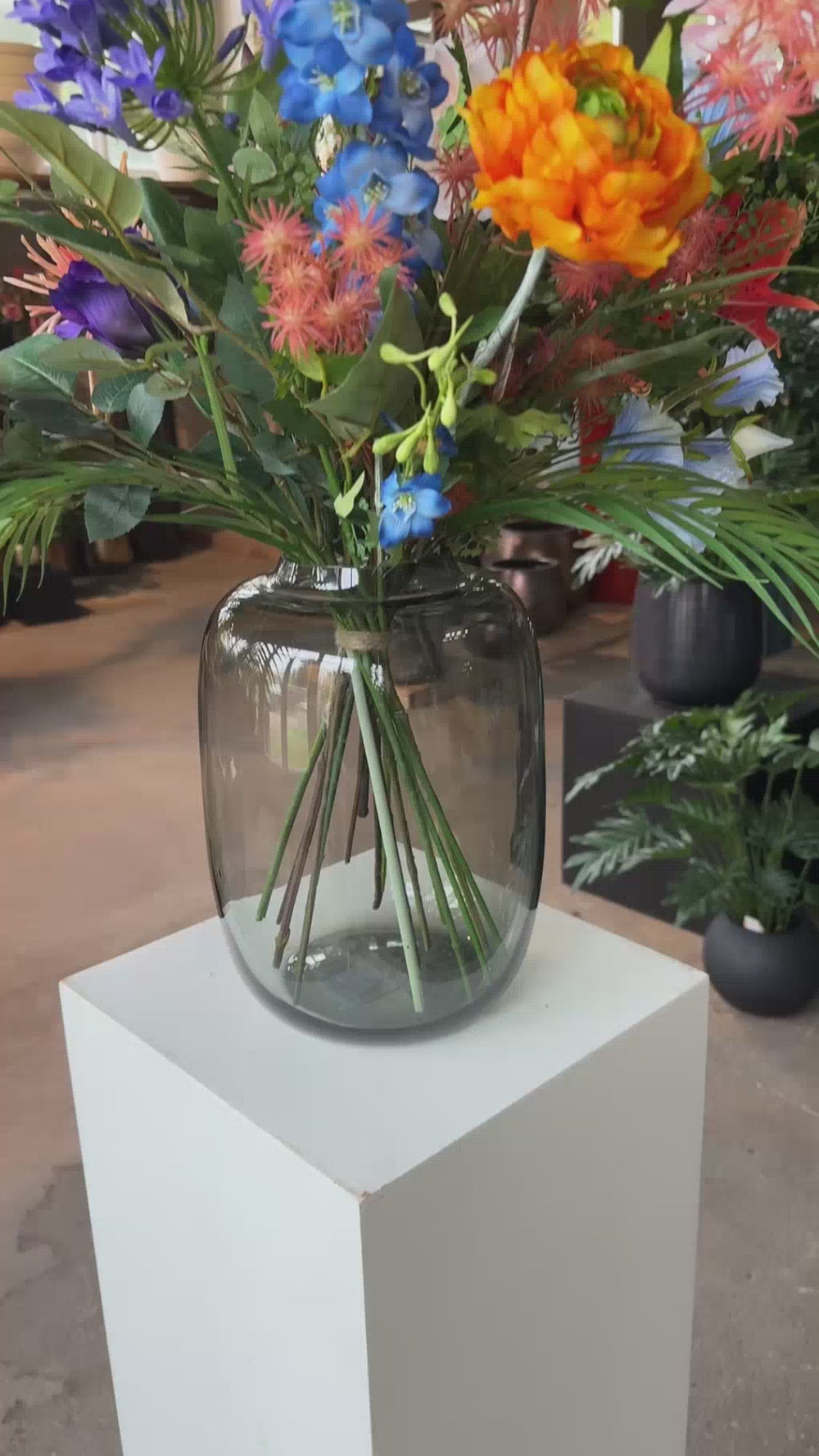 Kunstbloemen boeket Pretty Powerful samengesteld in glazen vaas